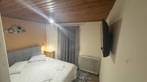 a bedroom with a white bed and a window at GUESTHOUSE ''ΧΡΥΣΑ'' in Dhimitsana