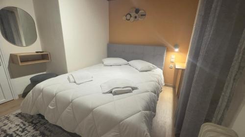 a bedroom with a white bed with a mirror at GUESTHOUSE ''ΧΡΥΣΑ'' in Dhimitsana