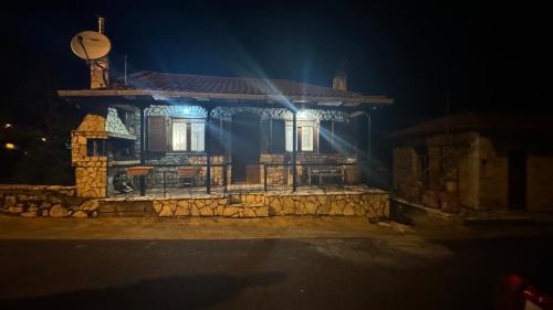 a small house with lights on it at night at GUESTHOUSE ''ΧΡΥΣΑ'' in Dhimitsana