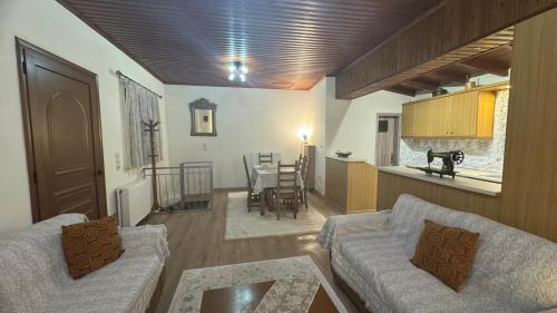a living room with two couches and a kitchen at GUESTHOUSE ''ΧΡΥΣΑ'' in Dimitsana