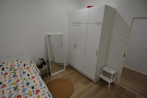 a bedroom with a bed and a large white cabinet at Villa Koivunoksa in Kerava