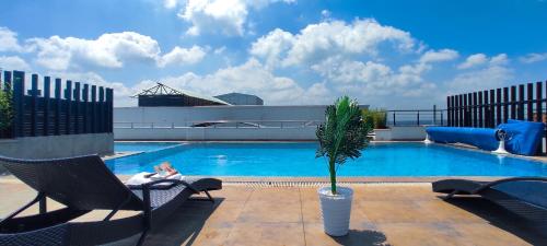 a woman sitting in a chair next to a swimming pool at The Hills View in Nairobi