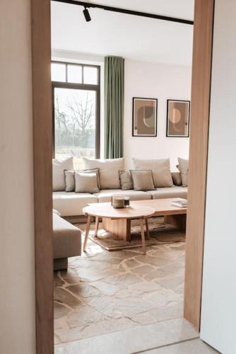 a living room with a couch and a table at Vakantiewoning Domein Hooverbosch in Zonnebeke