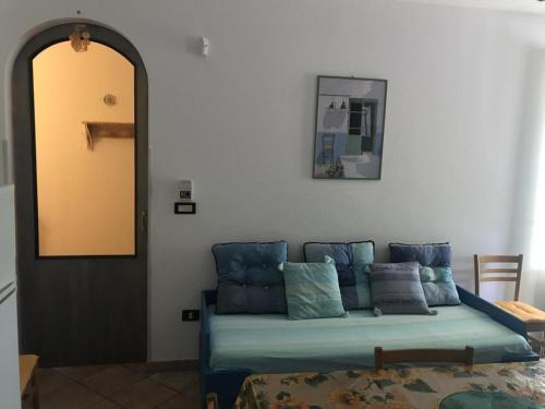 uma sala de estar com um sofá com almofadas em Villetta Mary em Torre Vado