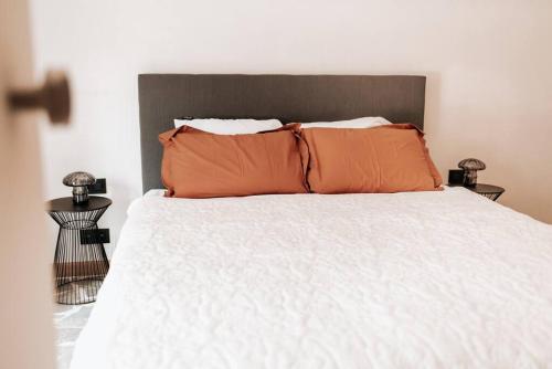 a bed with two orange pillows on top of it at Vakantiewoning Domein Hooverbosch in Zonnebeke