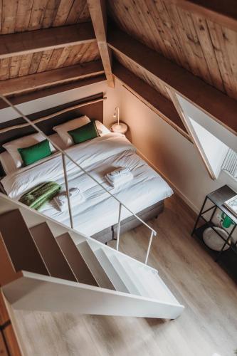 a bed in a room with a wooden ceiling at The Guest Apartments in Den Bosch