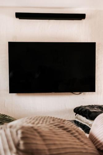 a flat screen tv hanging on a wall at Vakantiewoning Domein Hooverbosch in Zonnebeke