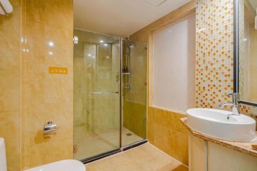 La salle de bains est pourvue d'une douche et d'un lavabo. dans l'établissement Chong Li Hotel Chengdu, à Chengdu