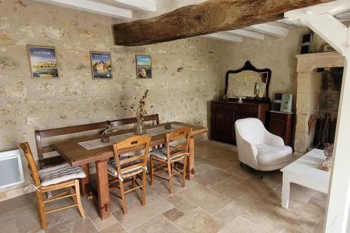 a dining room with a table and chairs and a mirror at Maison en lisière de forêt in Panzoult