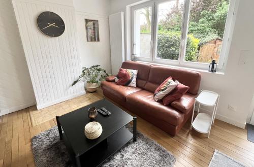 un salon avec un canapé en cuir marron et une table dans l'établissement La Citadelle, à Calais