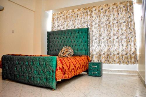 a green bed in a room with a window at Mogul's Palace (3 beds) Thika town in Thika