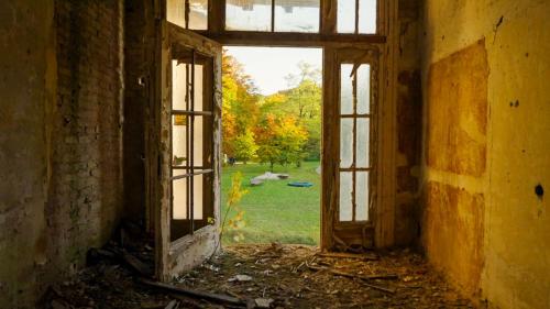 an open door in an old building with a view of a yard at Parkresidenz Lychen, Ferienwohnung 10 in Lychen