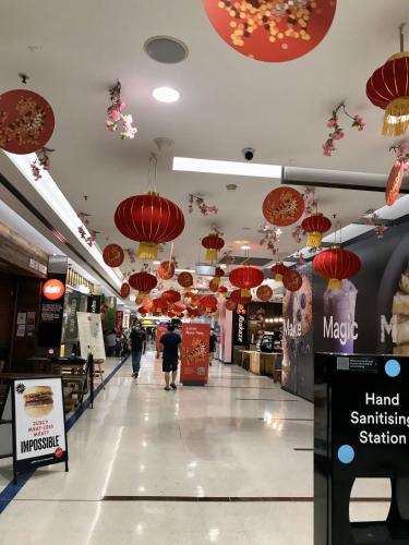 a shopping mall with red umbrellas hanging from the ceilings at Macquarie Treetops - Sydney 2BR Apt with FREE parking at Macquarie Park in Sydney
