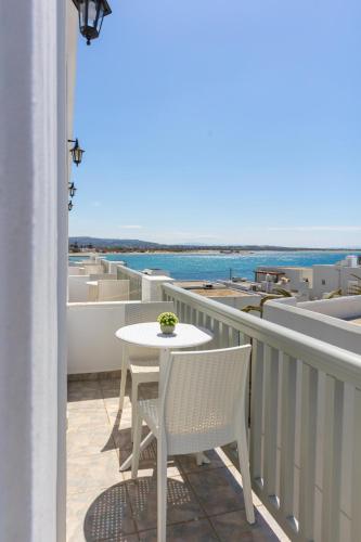 a white table and chairs on a balcony with the ocean at Kymata Hotel in Naxos Chora