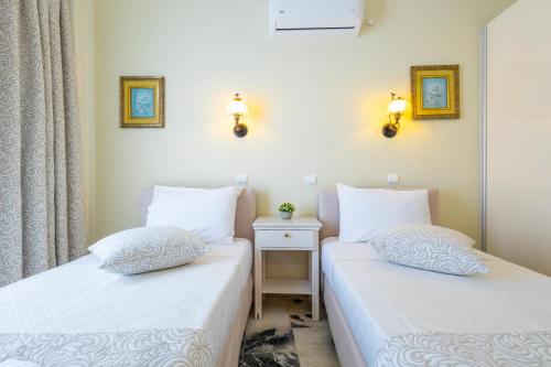 two beds sitting next to each other in a room at Kymata Hotel in Naxos Chora