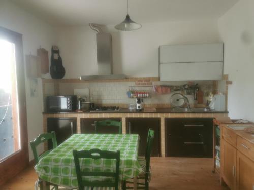 una cocina con una mesa con un mantel verde. en località Zarvenu (Murtas Artas) en Siniscola