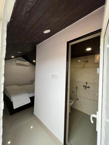 uma casa de banho com chuveiro e uma cama num quarto em The royal hut em Ajmer