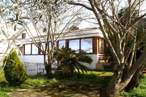 una casa blanca con árboles delante de ella en Camera Relax confortevole e riservata in villa, en Massa Lubrense
