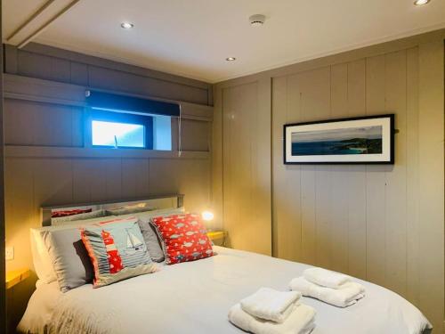 een slaapkamer met een groot wit bed met kussens bij Maisie Ryan's Beach Apartment in Caherdaniel