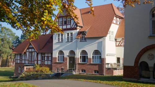 a large white building with a brown roof at Parkresidenz Lychen Ferienwohnung 2 in Lychen