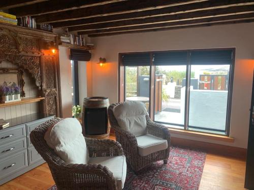 een woonkamer met 2 stoelen en een raam bij Maisie Ryan's Beach Apartment in Caherdaniel