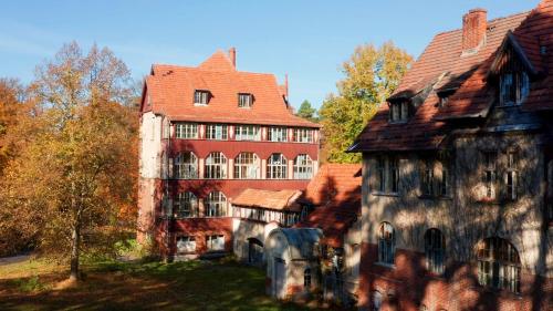 an old house with a red roof and two buildings at Parkresidenz Lychen Ferienwohnung 2 in Lychen