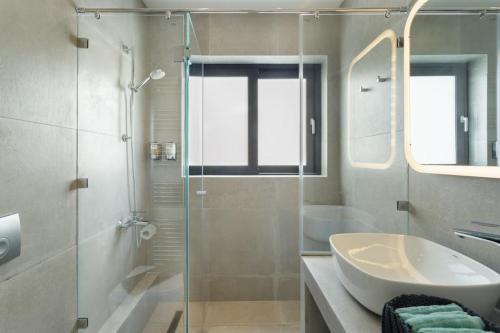 a bathroom with a glass shower and a sink at The Hostmaster Persephone Turquoise Opulence 1st floor in Athens