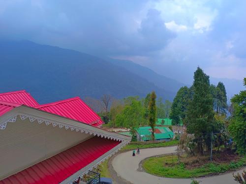a group of people walking around a park with red roofs at Sherpa Retreat Resort in Padamchen