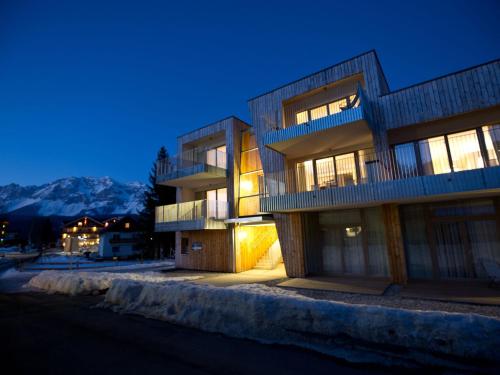 un edificio de noche con montañas en el fondo en Modern Apartment near Ski Area in Schladming, en Rohrmoos-Untertal