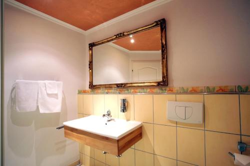 een badkamer met een wastafel en een spiegel bij B&B Siglistorf in Siglistorf