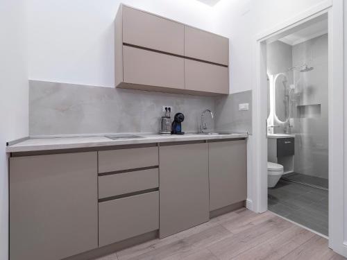 a white kitchen with a sink and a toilet at Apartments Mary in Budva