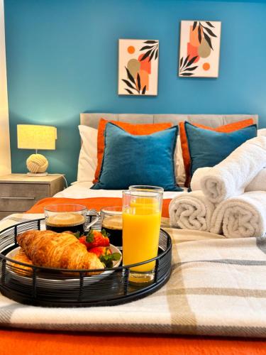 a table with a tray of food and orange juice at Sea views - Harbour view, Torquay Central location in Torquay