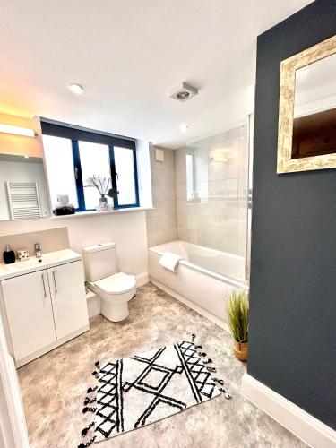 a bathroom with a toilet and a tub and a sink at Sea views - Harbour view, Torquay Central location in Torquay