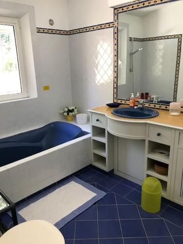 une salle de bain avec une baignoire, un lavabo et un miroir dans l'établissement Villa de plein pied pour 8 personnes à Gassin, à Saint-Tropez