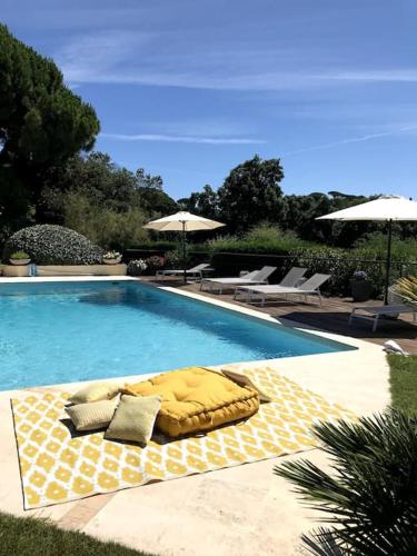 une grande piscine avec un coussin jaune dvisorvisorigunasteryasteryastery dans l'établissement Villa de plein pied pour 8 personnes à Gassin, à Saint-Tropez