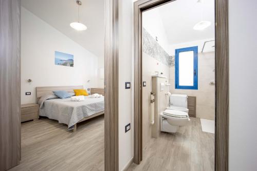 a bathroom with a bed and a toilet in a room at Acquamarina, appartamenti sul mare con piscina in Cardedu