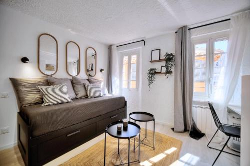 uma sala de estar com uma cama e duas mesas e espelhos em Studio de Luxe au Cœur de Grasse em Grasse