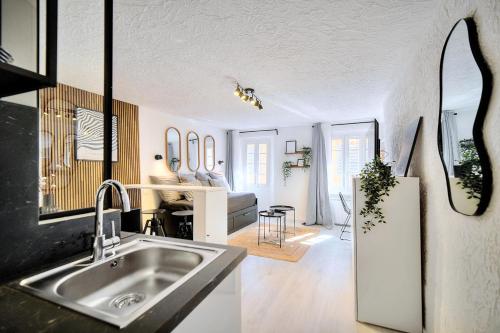 uma cozinha com um lavatório e uma sala de estar em Studio de Luxe au Cœur de Grasse em Grasse