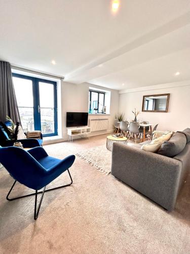 a living room with a couch and chairs and a television at Sea views - Harbour view, Torquay Central location in Torquay