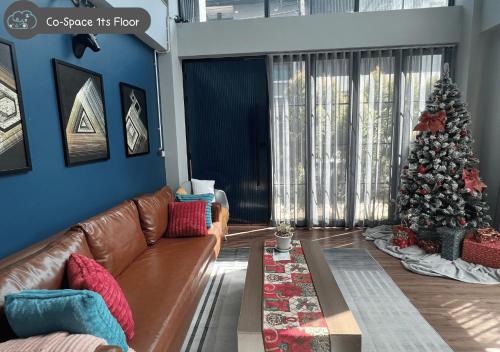a living room with a couch and a christmas tree at Scene Private hostel in Nan