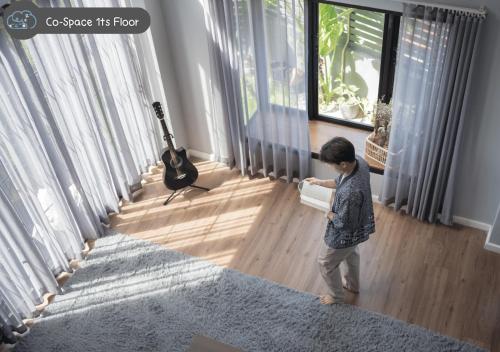 a young boy standing in a living room holding a book at Scene Private hostel in Nan