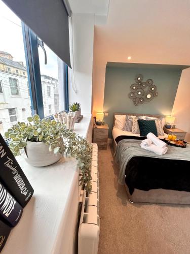 a room with two beds and a couch and a window at Sea views - Harbour view, Torquay Central location in Torquay
