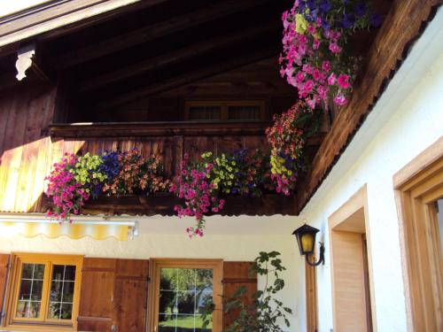 a house with flowers hanging from a balcony at Gästehaus Fischer in Rottach-Egern