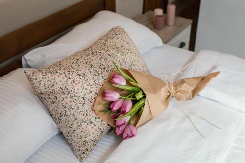 a bouquet of pink flowers sitting on a bed at Step to Kotor bay Guesthouse in Kotor