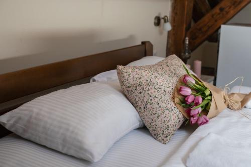 a bed with two pillows with flowers on it at Step to Kotor bay Guesthouse in Kotor