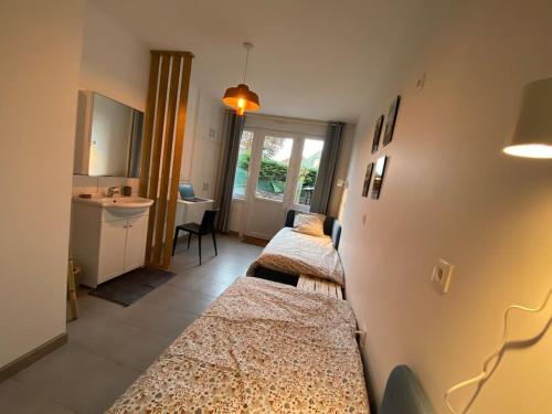 een kamer met 3 bedden en een wastafel bij Au 154 Bis - Bel appartement - Le Jardin in Duinkerke