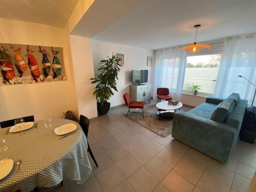 een woonkamer met een bank en een tafel bij Au 154 Bis - Bel appartement - Le Jardin in Duinkerke