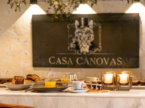 a table with plates of food and candles on it at Boutique Hotel Casa Cánovas in Cádiz