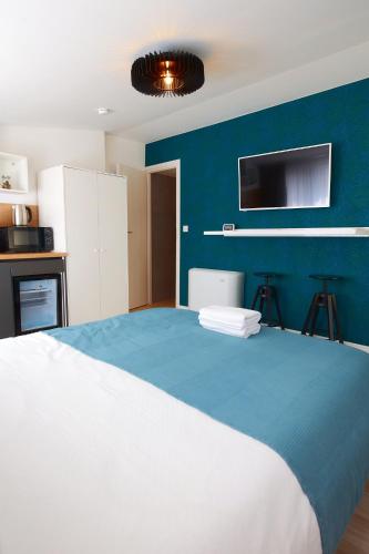 a bedroom with a large bed with a blue wall at PRIMA APARTMENTS in Satu Mare