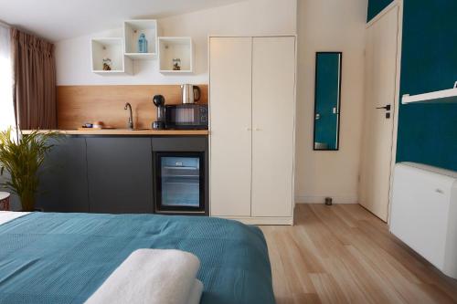 a bedroom with a bed and a kitchen at PRIMA APARTMENTS in Satu Mare